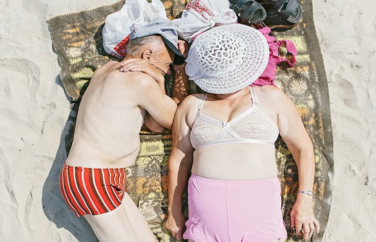 Série fotográfica mostra pessoas tirando uma soneca na praia